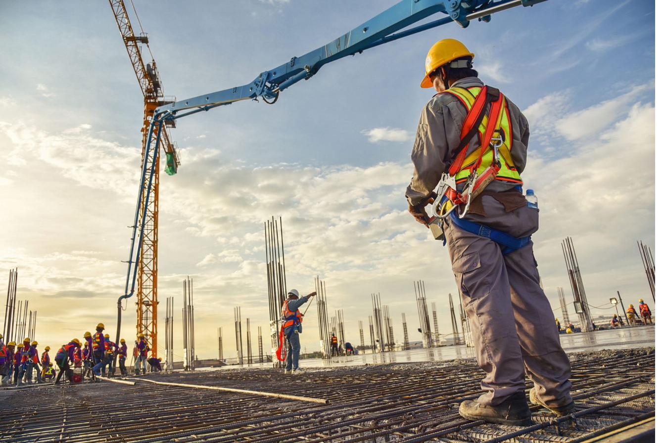 Construction worker in safety harness on jobsite at golden hour