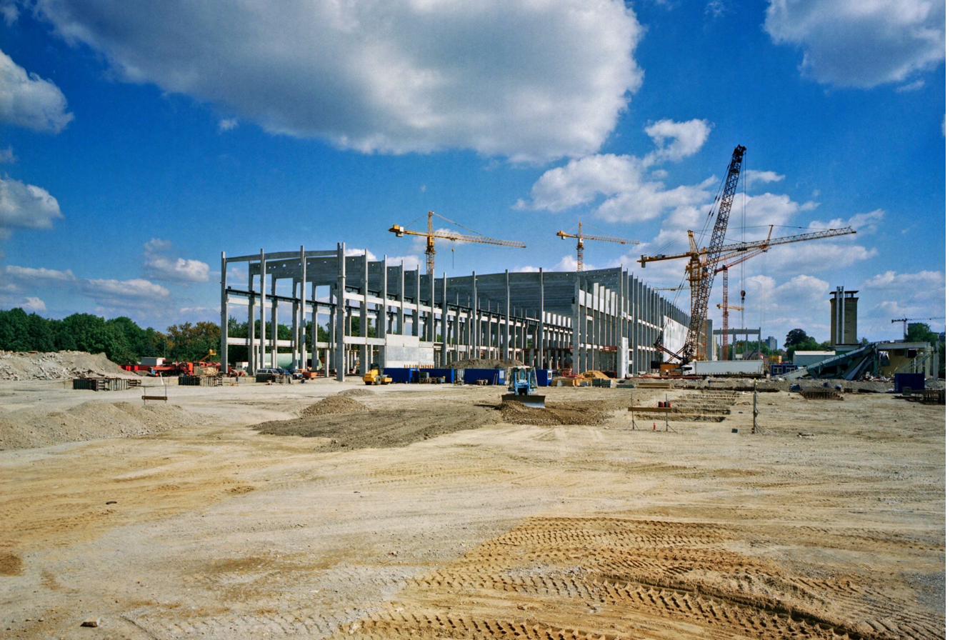 Large-scale industrial construction project with cranes and concrete frame